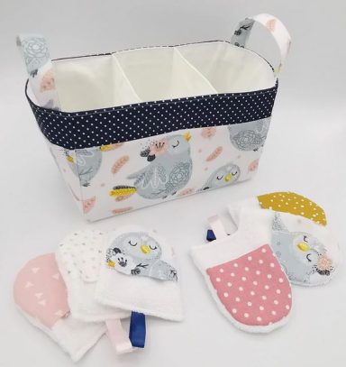 Panier de rangement avec des motifs d'oiseaux et des gants de toilette pour bébé assortis.